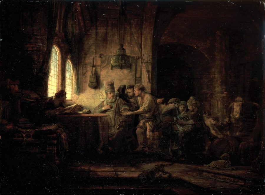 At evening, the vineyard owner sits at a table and pays a labourer while other workers wait in the shadowed room.